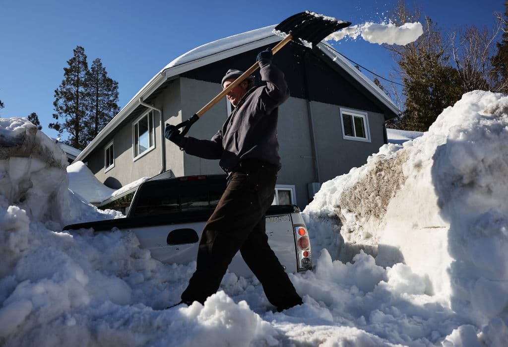 Un residente palea nieve después de que una serie de tormentas invernales arrojaron fuertes nevadas en las montañas de San Bernardino en el sur de California el 3 de marzo de 2023 en Crestline, California.