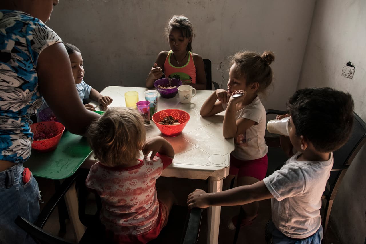 Decenas de niños hacen fila cada día para entrar al comedor de Sustento en La Vega. Allí reciben un plato de arroz, carne molida, ensalada y una ración de lactovisoy, una bebida con carbohidratos y proteínas para combatir la desnutrición.