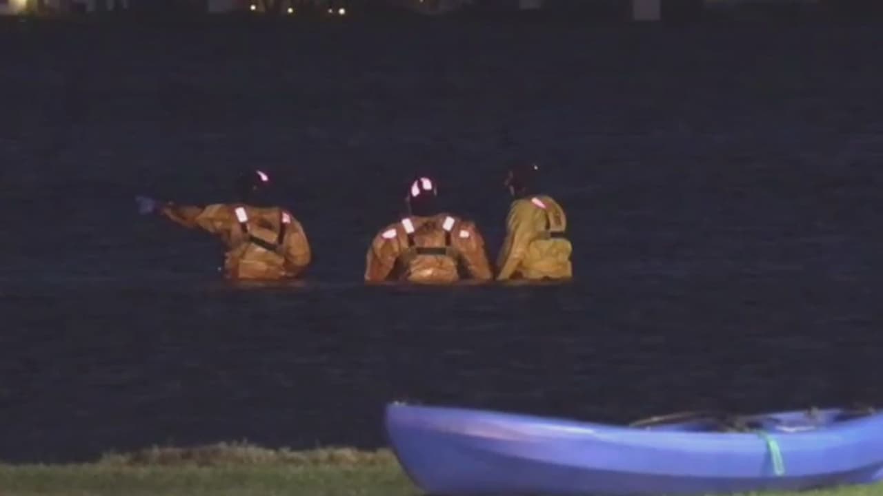 Equipos de rescate investigan el lago durante la noche del viernes.