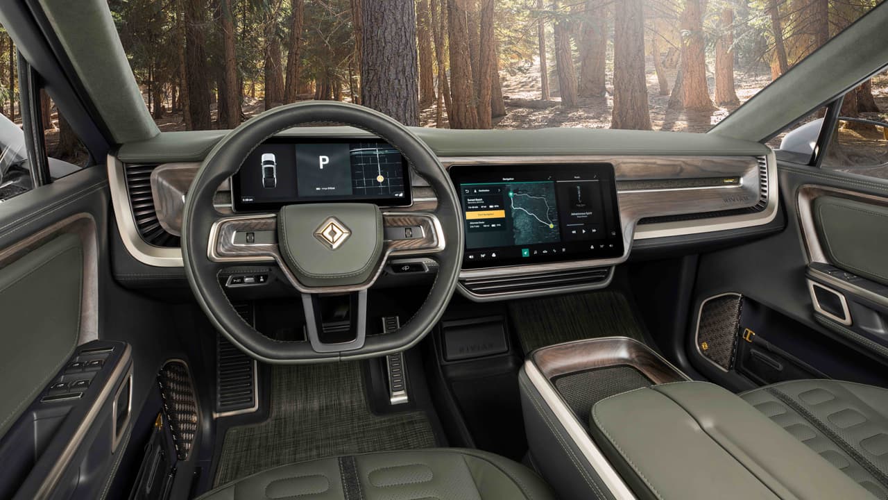 El interior de la Rivian R1T es
<b>elegante y lujoso</b>, y mucho menos minimalista y más convencional, al menos a primera vista, que el interior de ninguno de los modelos Tesla. Lo que si toma de Tesla, es la utilización de enormes pantallas sensibles al tacto, en este caso dos, para la interacción con instrumentos y controles. La SUV R1S muestra un tablero similar.