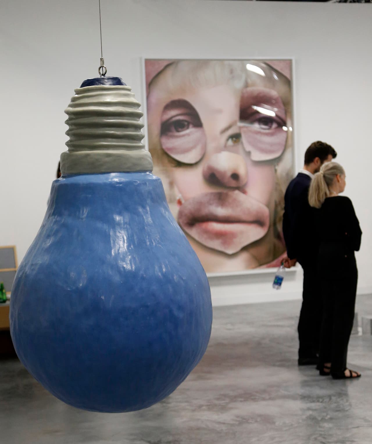 Art patrons walk through a gallery during Art Basel in Miami on November 30, 2016. Art Basel represents over 250 art galleries at the Miami Beach Convention Center and is considered one of the world's largest art festivals with art events throughout the city. / AFP / RHONA WISE / RESTRICTED TO EDITORIAL USE - MANDATORY MENTION OF THE ARTIST UPON PUBLICATION - TO ILLUSTRATE THE EVENT AS SPECIFIED IN THE CAPTION (Photo credit should read RHONA WISE/AFP/Getty Images)