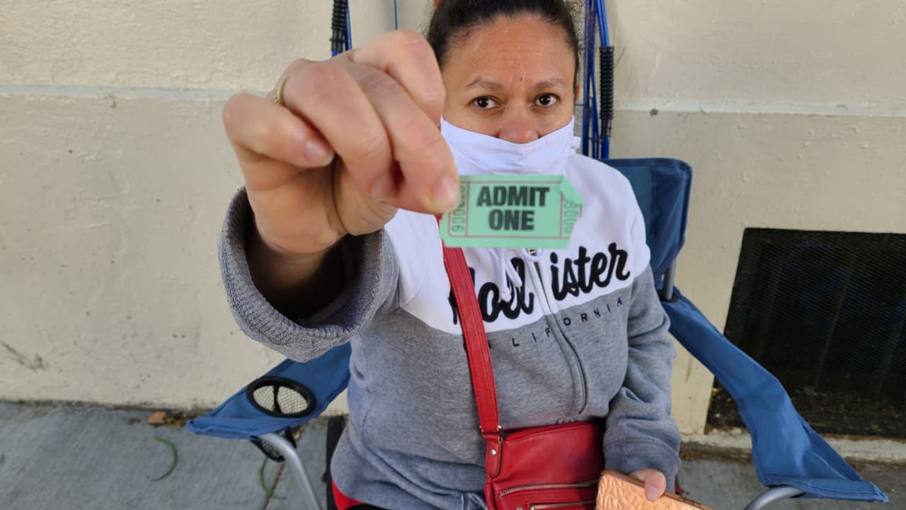 Yeymi muestra el boleto que le dieron para marcar su número en la fila, a la que llegó un poco después de las 6:30 am.