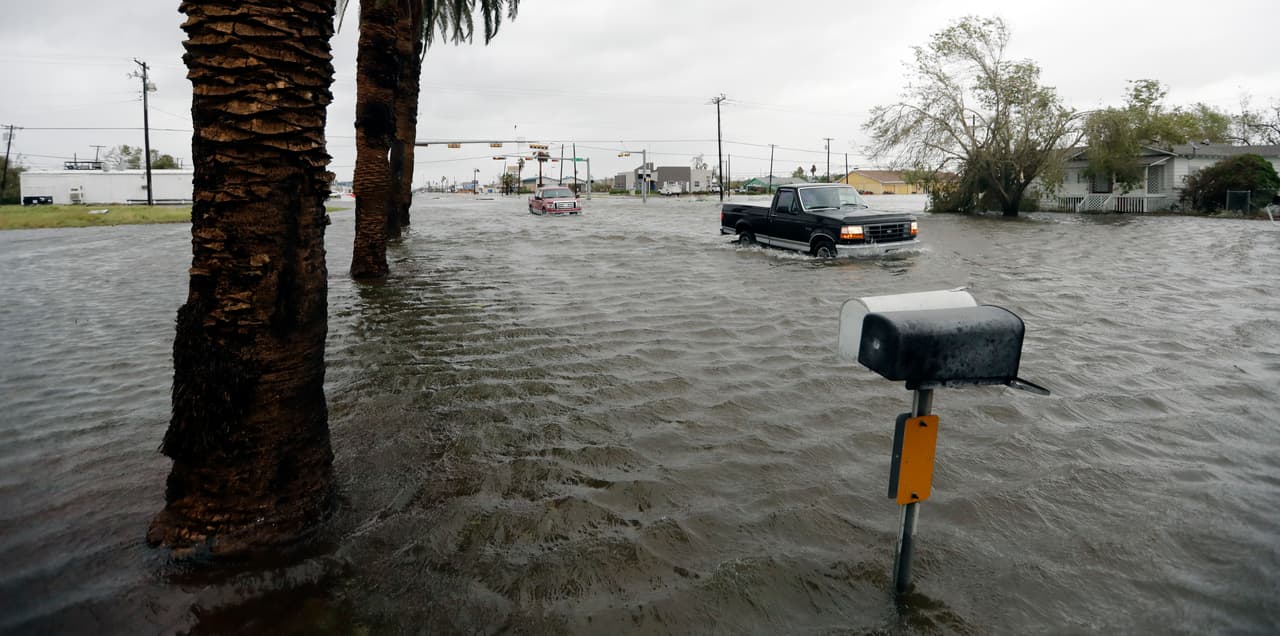 Varios vehículos avanzan en medio de una inundación provocada por el huracán Harvey, el 26 de agosto de 2017 en Aransas Pass, Texas. (AP Foto/Eric Gay)