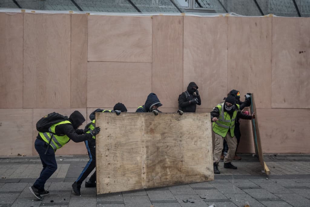 Los manifestantes cargan bloques de madera que usan a modo de barricadas para protegerse de los embates de la policía.