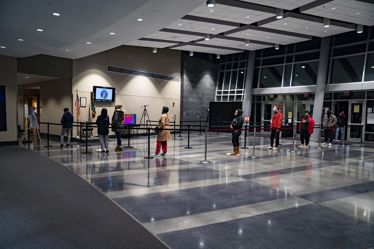Los votantes hacen fila antes de que se abran las puertas en el Centro Comunitario del condado de Cobb este martes 5 de enero de 2021 en Atlanta, Georgia. Las urnas abrieron para definir las dos elecciones de segunda vuelta en las que se enfrentan los senadores titulares republicanos David Perdue y Kelly Loeffler contra los candidatos demócratas Rev. Raphael Warnock y Jon Ossoff.