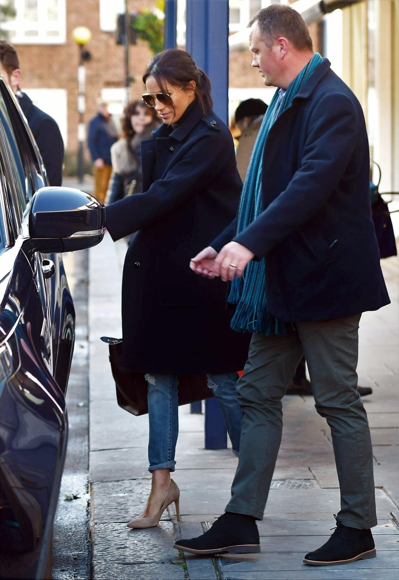 En esta ocasión, Meghan Markle eligió unos jeans rotos de maternidad de la marca H&M, unos tacones de Stuart Weitzman y un suéter de cuello alto azul marino.