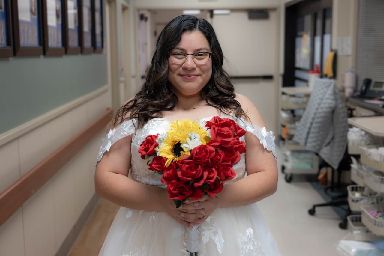 Michelle Ávila lució su vestido blanco y su ramo de rosas rojas y girasoles. A pesar de lo poco común de la boda, la novia lució una bella sonrisa.