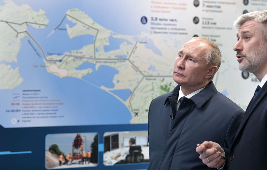 Russian President Vladimir Putin listens to Transport Minister Yevgeny Ditrikh after the opening ceremony of the railway part of the Crimean Bridge, connecting Crimea to mainland Russia in Taman on December 23, 2019.