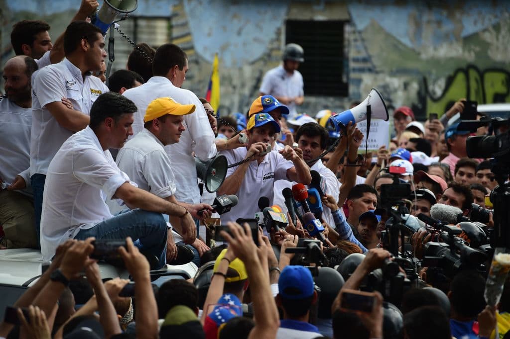 El líder opositor y ex candidato presidencial Henrique Capriles da un discurso a los manifestantes en el que asegura que deben mantenerse en la calle protestando: "Esta no es la hora de desistir, es la hora de resistir (...). 
<b>Si todos los venezolanos nos unimos no habrá cúpula corrupta que pueda con la fuerza de cada uno de nosotros"</b>, dijo. (RonaldoSchemidt/AFP/GettyImages)