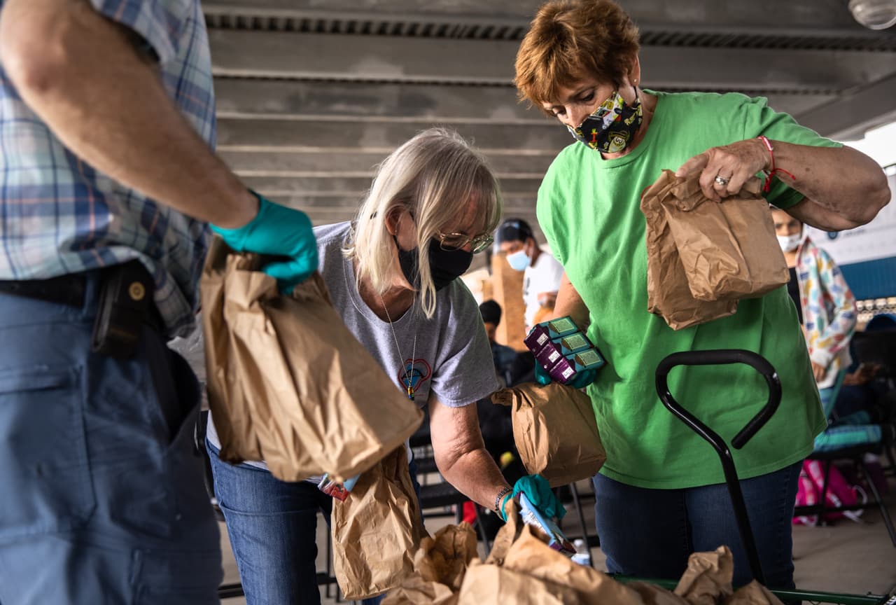 <b>Llegó la comida. </b>Voluntarios del grupo de asistencia a inmigrantes Team Brownsville distribuyen el almuerzo a un grupo de al menos 25 solicitantes de asilo a quienes se les permitió cruzar oficialmente desde un campamento de migrantes en México a los Estados Unidos.