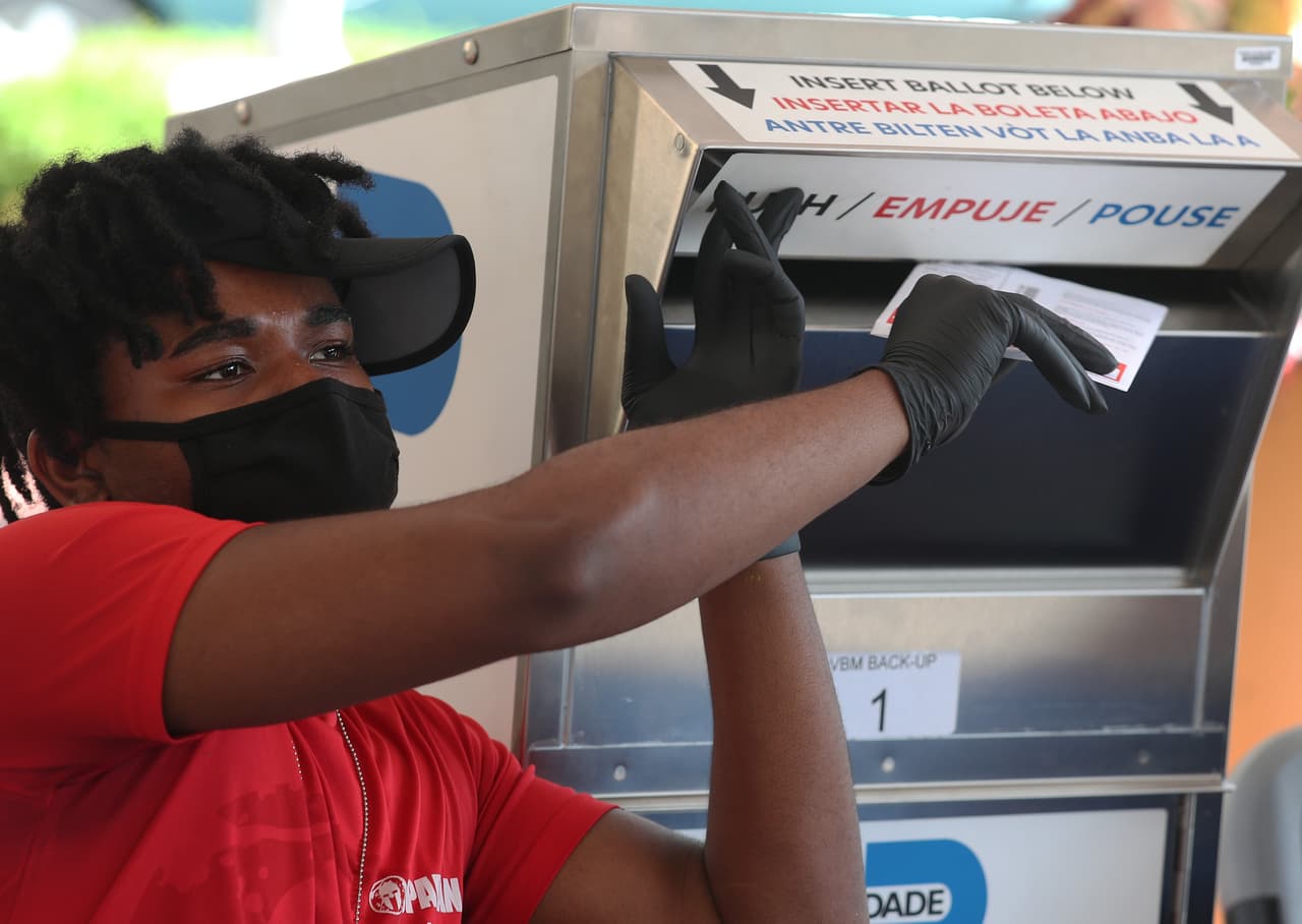 Un empleado del departamento de elecciones coloca una boleta de votación por correo en Doral, Florida, el 14 de octubre. Casi dos millones de personas han votado por correo en este estado clave para la elección, según las estadísticas publicadas por la División de Elecciones de Florida.