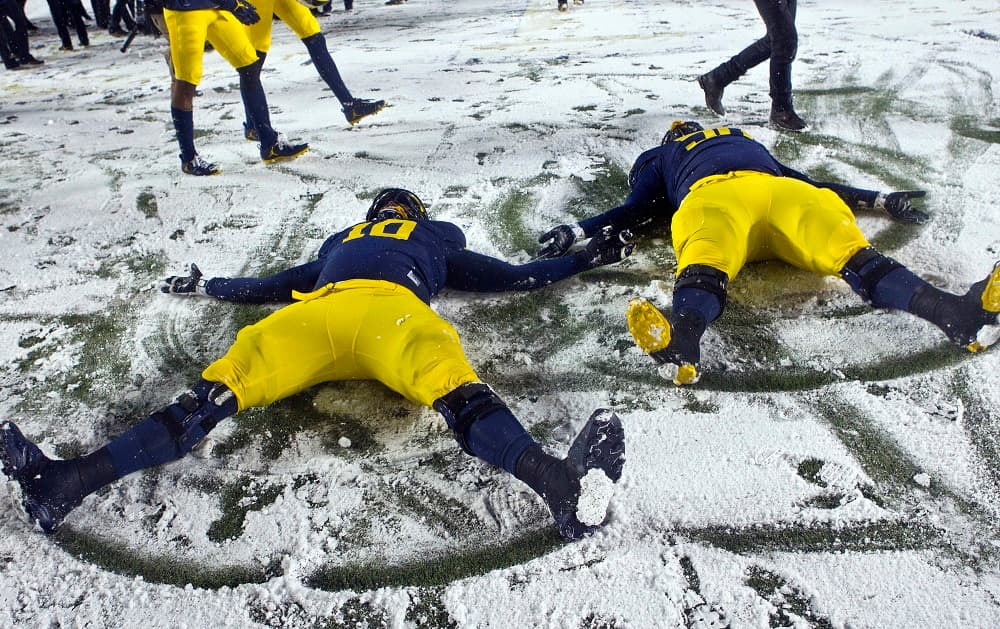 La nieve ha afectado a varios estados durante el fin de semana, como Michigan. En la imagen se aprecia a dos jugadores en el suelo haciendo dibujos con la nieve en el Michigan Stadium en Ann Arbor.