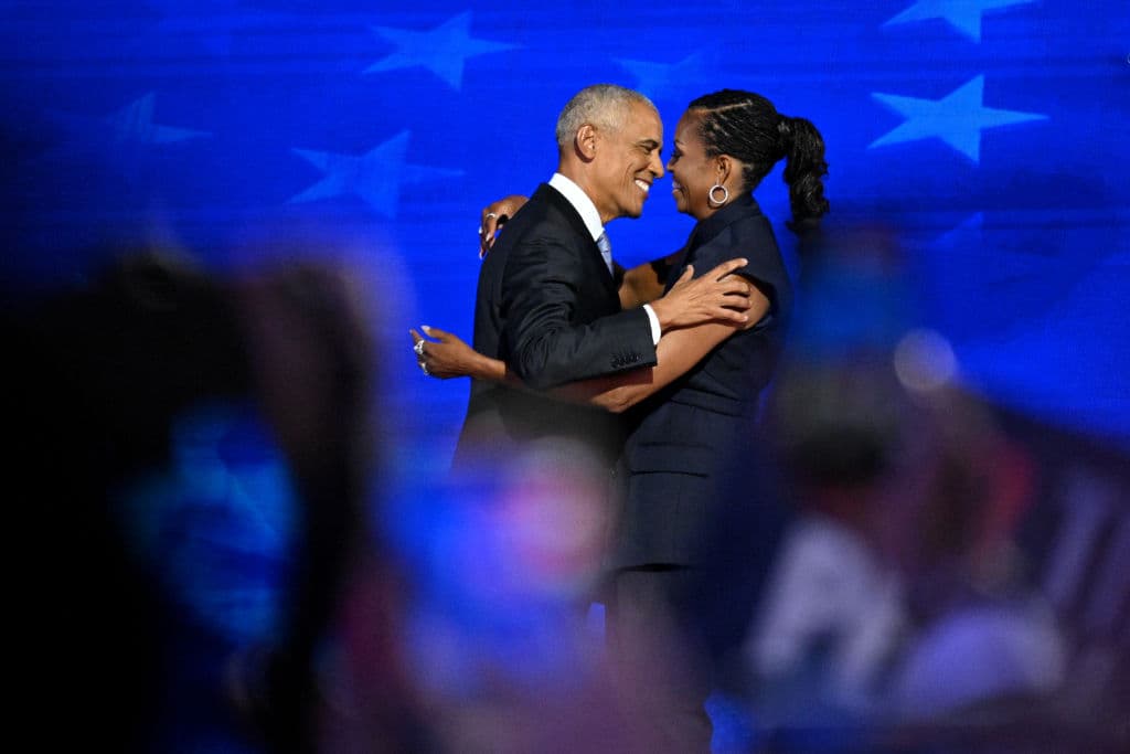 El expresidente Barack Obama (izq.) abraza a su esposa, la exprimera dama Michelle Obama, cuando llega al escenario para hablar en el segundo día de la Convención Nacional Demócrata (DNC, por sus siglas en inglés) en el United Center en Chicago, Illinois, el 20 de agosto de 2024.