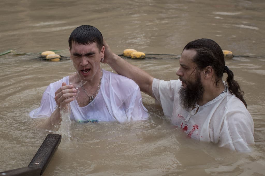 Un hombre sale del río tras ser bautizado durante el Jueves Santo en Israel.