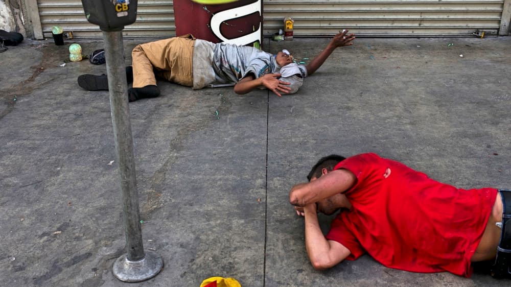 Dos drogadictos alucinan en una acera de Skid Row apestosa a orines.