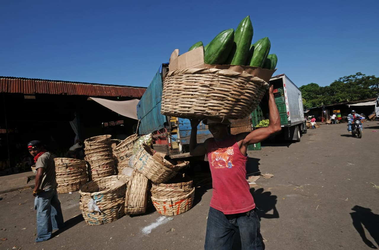 Un hombre carga un canasto lleno de frutas en el mercado de mayoreo en Managua (Nicaragua)