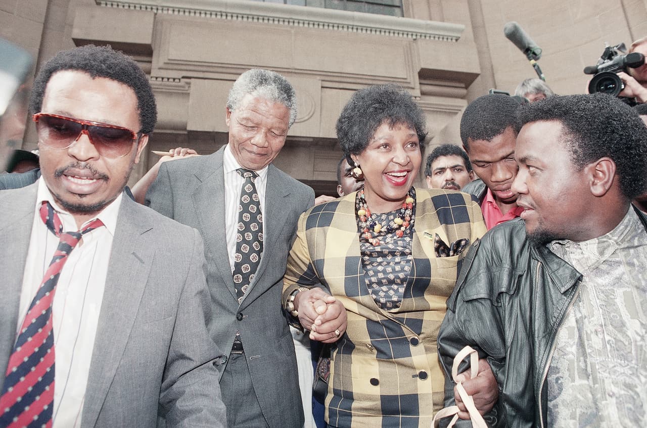 En 1991 fue acusada del asesinato del activista Stompie Seipei, quien fue encontrado cerca de su casa en Soweto con un corte en la garganta. Uno de los colaboradores de Madikizela-Mandela se declaró culpable del asesinato por lo que ella fue condenada solo por secuestro y agresión. Su sentencia de seis años de cárcel se redujo a una multa tras una apelación. En la fotografía a su llegada a la Corte Suprema de Suráfrica donde enfrentó los cargos, acompañada por Nelson Mandela.