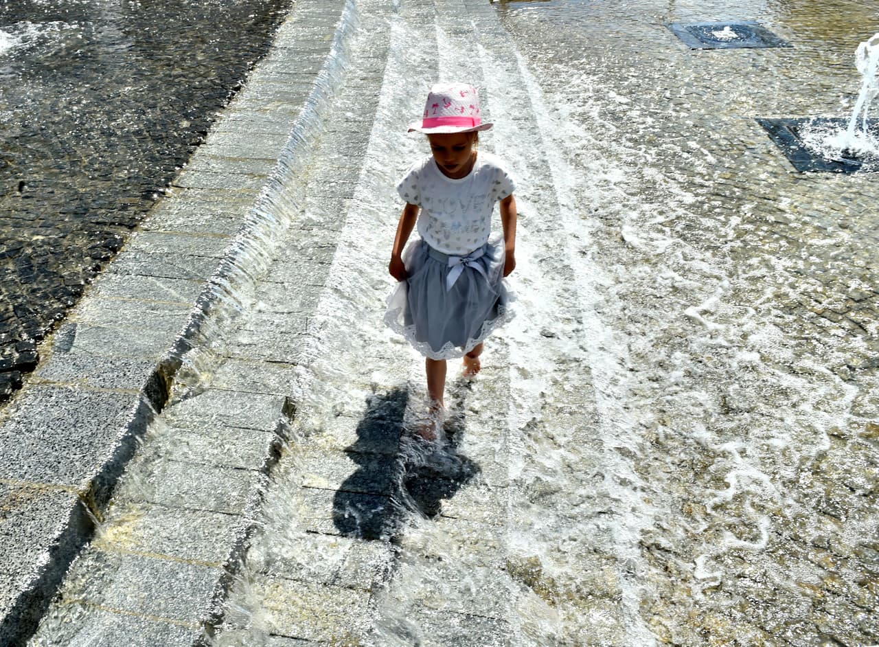 Los niños pequeños y los ancianos son más susceptibles al calor porque sudan menos. Esta niña moja sus pies descalzos en una fuente en Kiev, Ucrania, donde también se experimentan altas temperaturas.