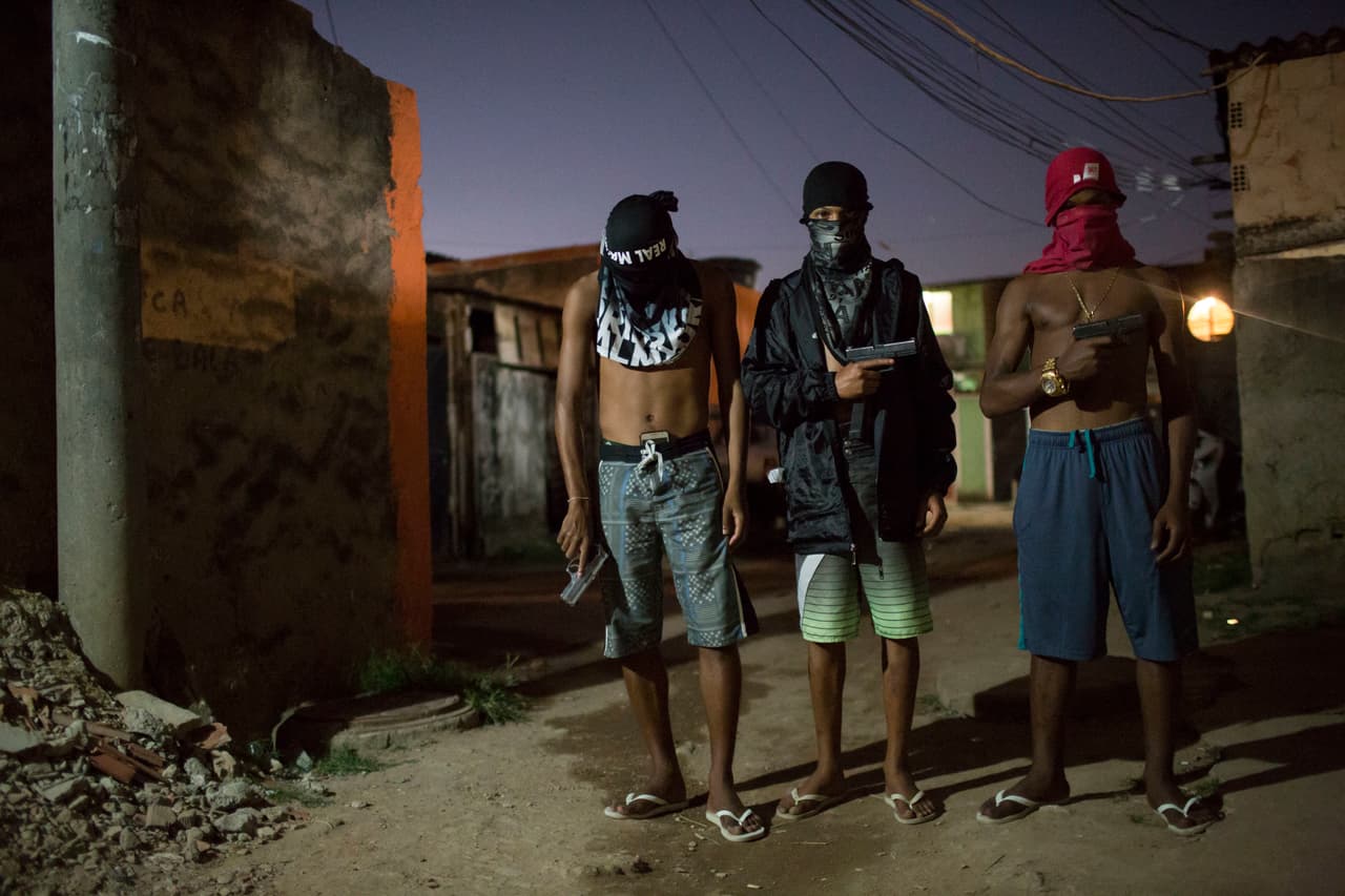 En esta imagen del 11 de julio de 2016, jóvenes traficantes de drogas posan para fotos con sus armas en la mano en una favela de Río de Janeiro, Brasil. Los adolescentes llevan sus armas a la vista mientras corren en sandalias por un laberinto de callejones. Cuando los periodistas de Associated Press visitan zonas con autorización de las pandillas, los que acceden a ser fotografiados se cubren el rostro para que no se les identifique. (AP Foto/Felipe Dana)