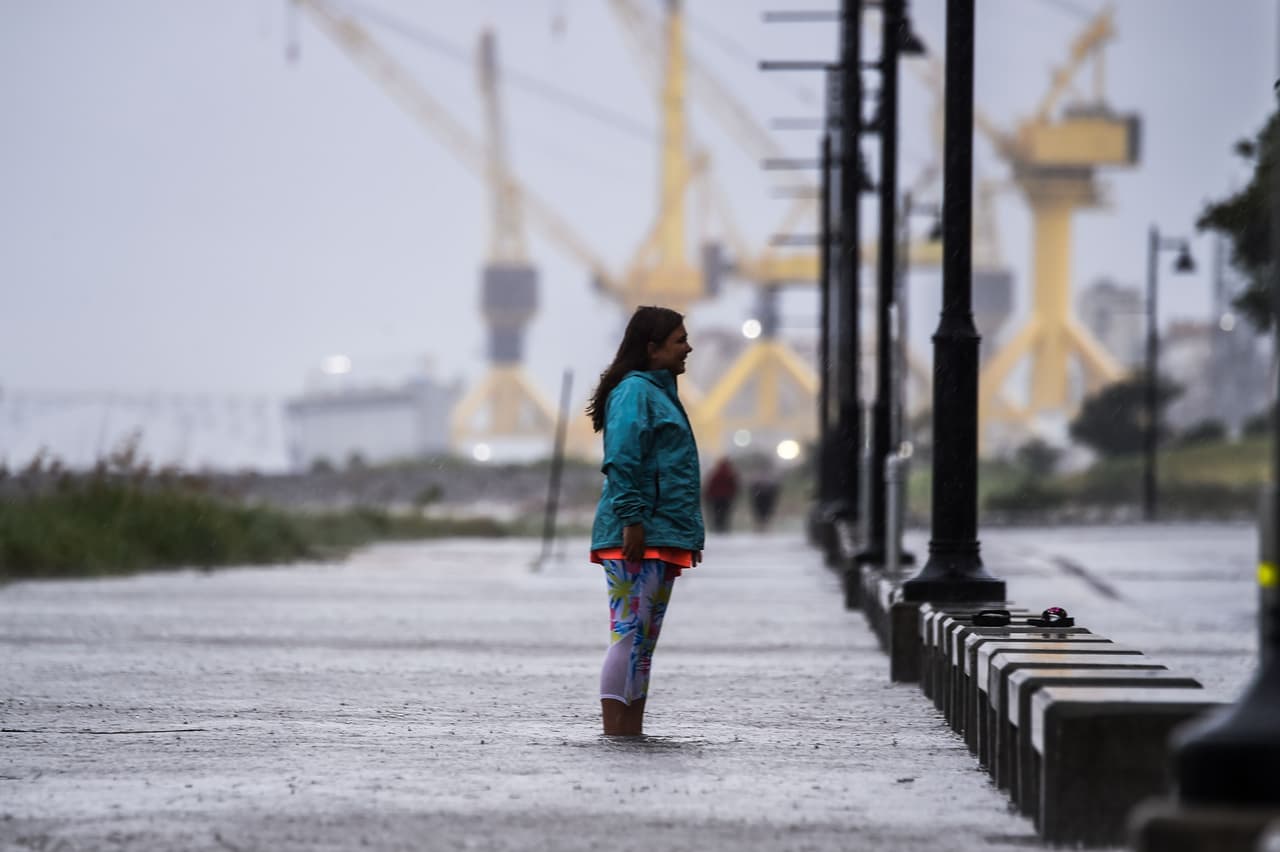 Una residente de Pascagoula, en Mississippi, camina por una vía inundada horas antes del arribo del huracán Sally. En la vecina Louisiana, en apenas dos semanas, dos fenómenos naturales dejaron lluvias torrenciales e inundaciones catastróficas: Marco y Laura.