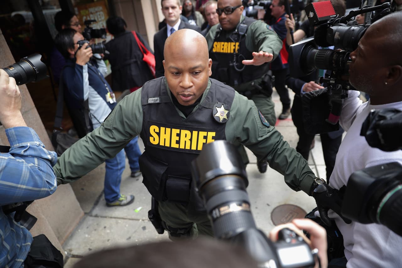 Un policía frente a los fotógrafos de la prensa, en Baltimore, en mayo pasado.