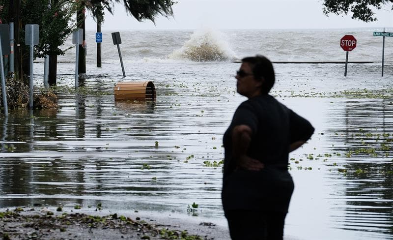 Las autoridades esperan que Barry se desplace hacia el centro del estado a lo largo de las horas y expresaron su esperanza de que vaya perdiendo rápido su fuerza. Una mujer se para frente a un camino inundado cerca del Lago Pontchartrain en Mandeville, Louisiana.