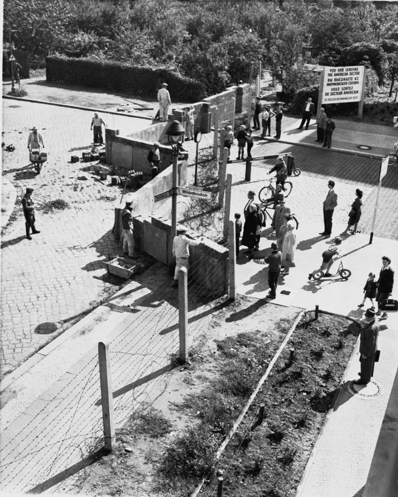 El muro separó a Berlín oriental del occidental durante 28 años. Una verja de alambres de púas fue sustituida progresivamente por un muro de hormigón. En esta fotografía de 1961, funcionarios occidentales vigilan a los obreros orientales que construyen la barrera.
