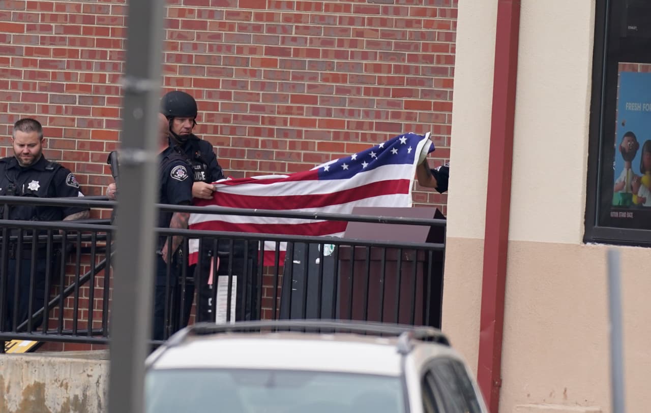 Dos policías sacan una bandera de EEUU de uno de los establecimientos del centro comercial donde ocurrió la masacre, que dejó "varios heridos", según las autoridades. Al menos 10 personas murieron, entre ellos un agente de policía. Una fuente cercana a la investigación 
<a href="https://twitter.com/Pervaizistan/status/1374162636854730752" target="_blank">dijo a CNN</a> que el atacante había usado un rifle AR-15: un arma capaz de disparar 400 rondas por minuto.