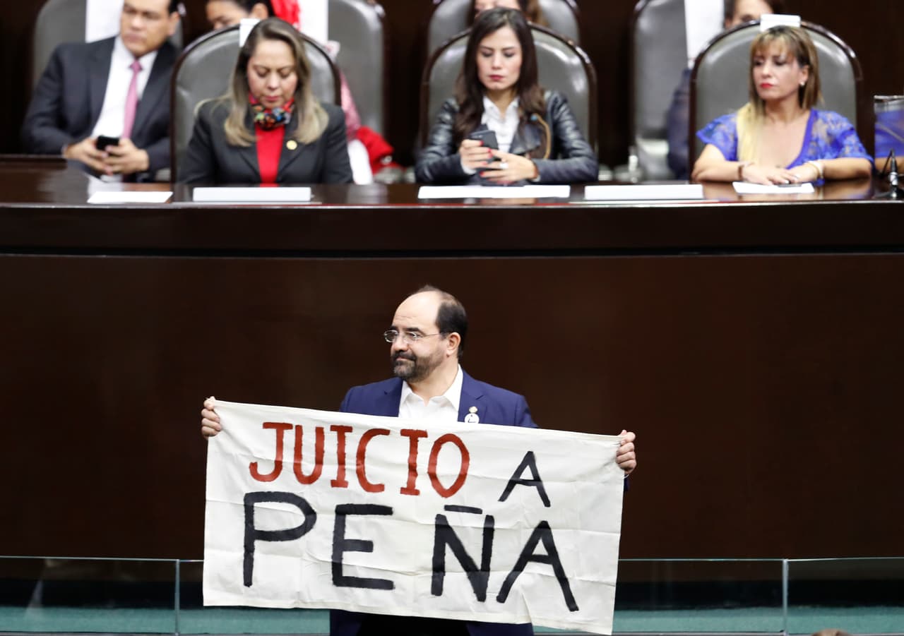 El legislador Emilio Álvarez Icaza levanta un cartel que dice "Juicio a Peña" en referencia al expresidente mexicano Enrique Peña Nieto.