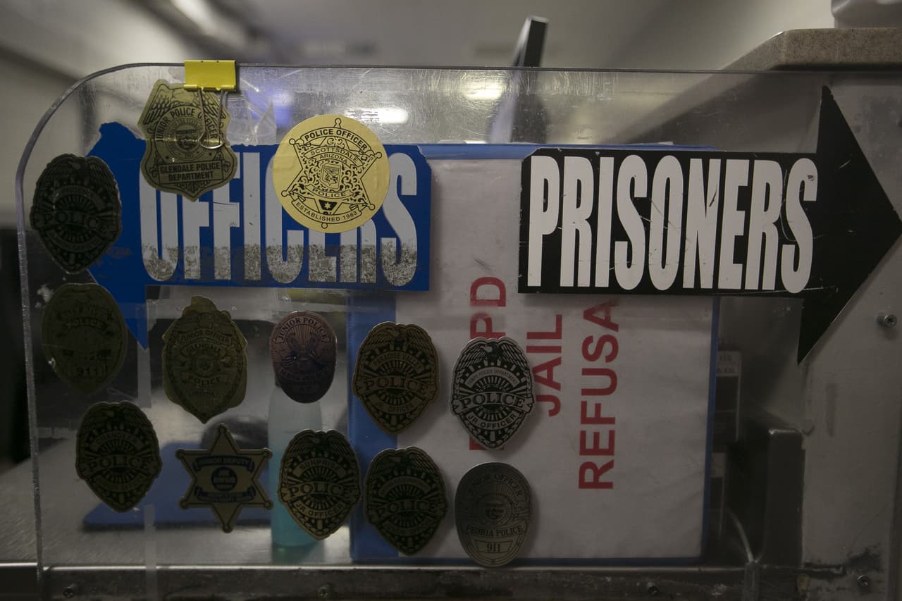 A sign points prisoners and officers in separate directions at the early booking stage in the 4th Avenue Jail in Phoenix, Ariz. on Feb. 22nd, 2017.