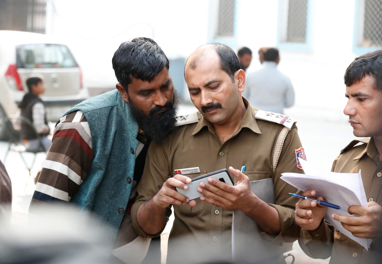 En la imagen se ve como un hombre mira fotografías tomadas por la policía buscando identificar a sus familiares o conocidos entre las víctimas.