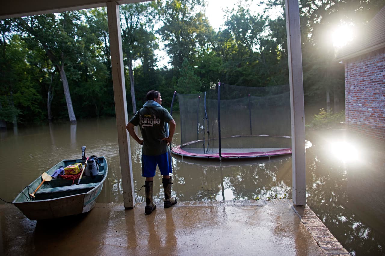 David Key, habitante de Prairieville, mira el inundado patio trasero de su casa.