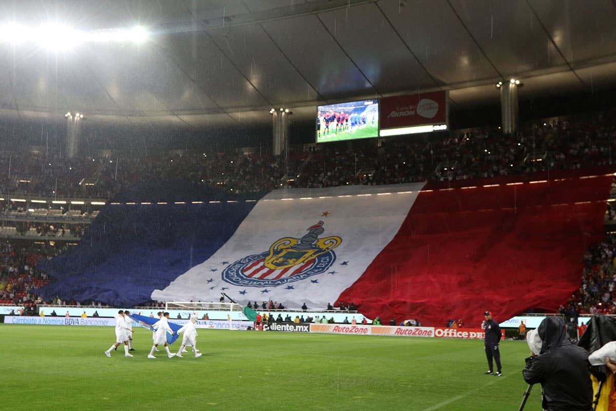 Una bandera gigante desplegaron los fanáticos de Chivas en el Estadio Akron durante la salida de los equipos.