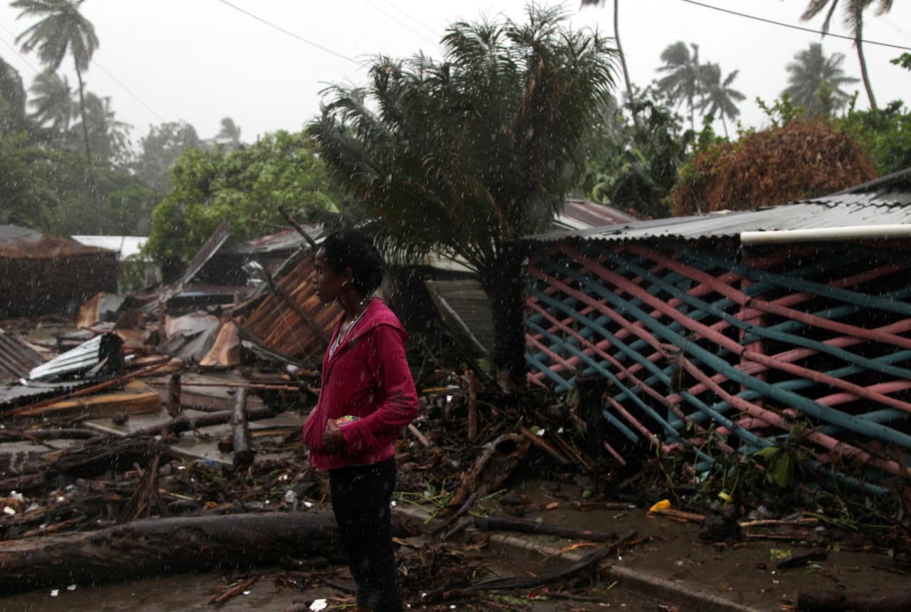 Una mujer contempla bajo la lluvia la destrucción de construcciones en Nagua. Sin embargo las zonas afectadas de República Dominicana podrían abarcar desde Cabo Engano hasta su frontera norte con Haití.