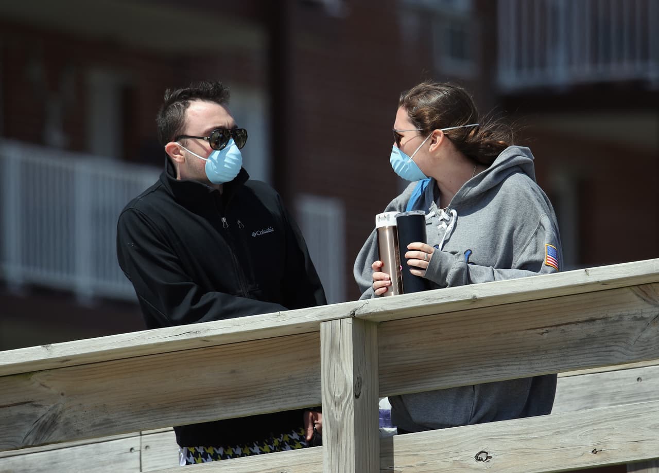 Una pareja convive, con sus caras tapadas, en una playa de Long Beach.