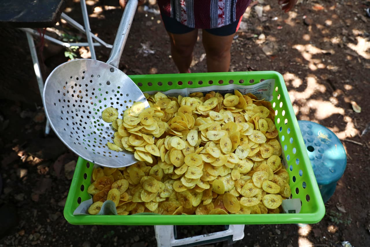 María Teresa Carballo fríe chips de plátano afuera de su casa en Santa Ana, El Salvador.