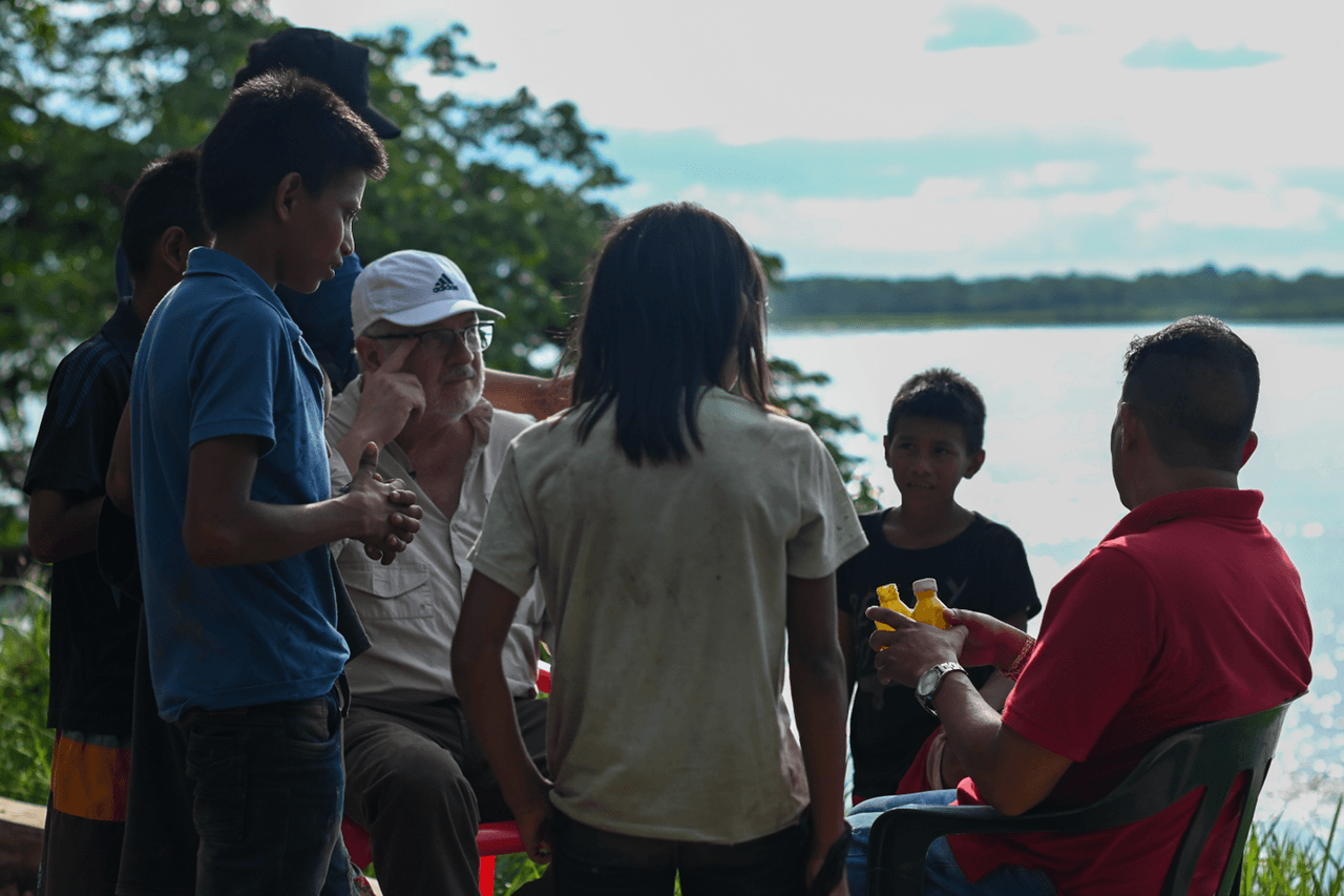 Niños indígenas le entregan al misionero Gustavo Ricardo los frascos amarillos de pegante Boxer que llevaban escondidos debajo de su ropa.
