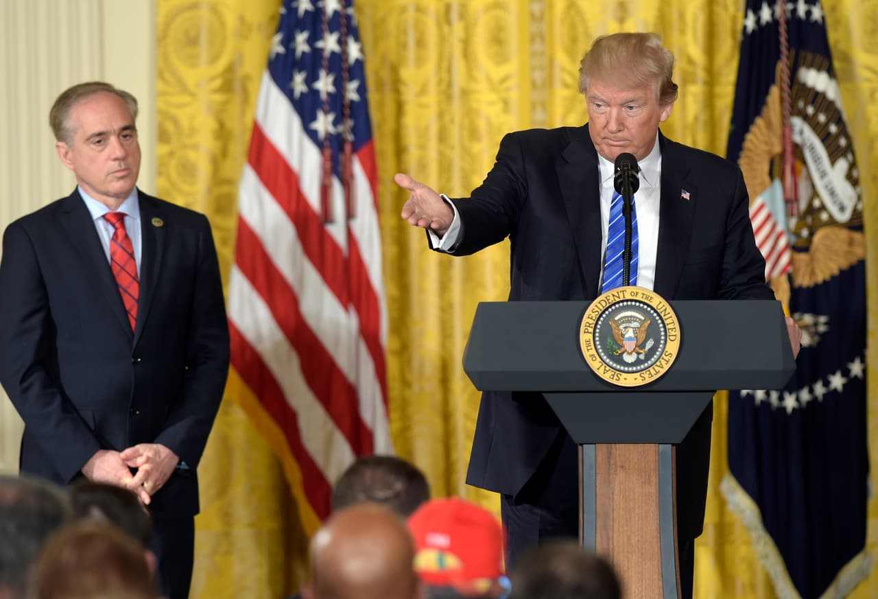 El presidente Donald Trump en el podio, acompañado del ahora despedido secretario de Asuntos de Veteranos, David Shulkin.