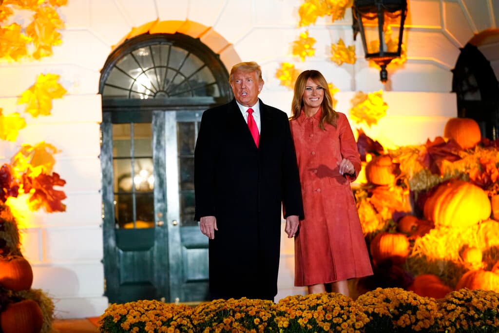 El presidente Donald Trump y la primera dama Melania Trump saludan a invitados a una celebración por el Día de las Brujas en la Casa Blanca, en Washington, el domingo 25 de octubre del 2020.