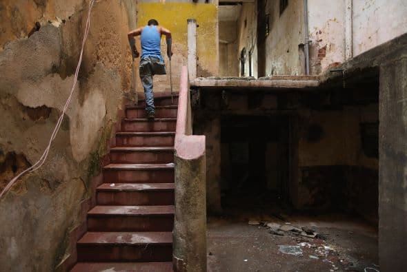Evis Leyva Carballo utiliza muletas para moverse en una pierna en el interior de un edificio abandonado que él llama hogar frente al Malecón en La Habana.