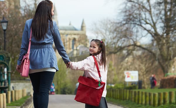 Mother Walking Daughter To School Along Path