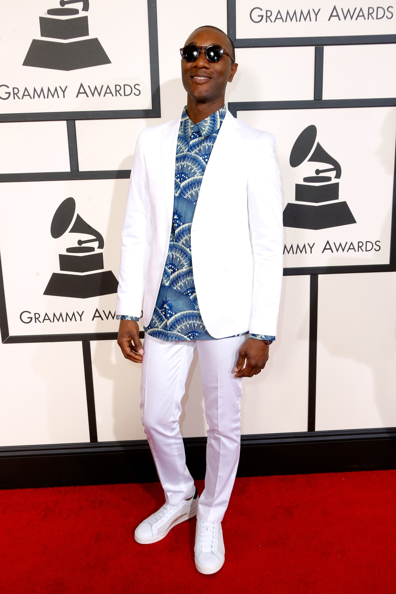 ¿Corbata y traje negro? Aloe Blacc decidió que lo mejor era ir de 'total white' con una camisa estampada que desobedecía toda etiqueta. Los tenis son oficialmente los zapatos de la formalidad.