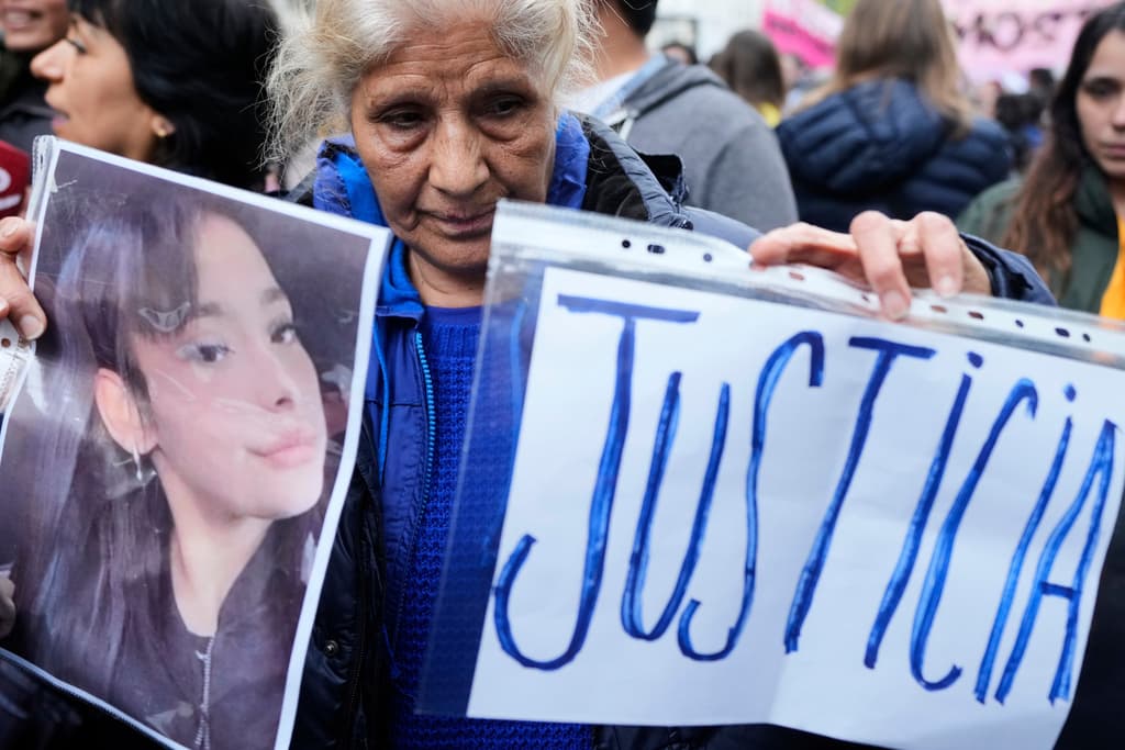 Una mujer sostiene una imagen de Lara Gutiérrez y pide justicia por el triple asesinato de las tres jóvenes.