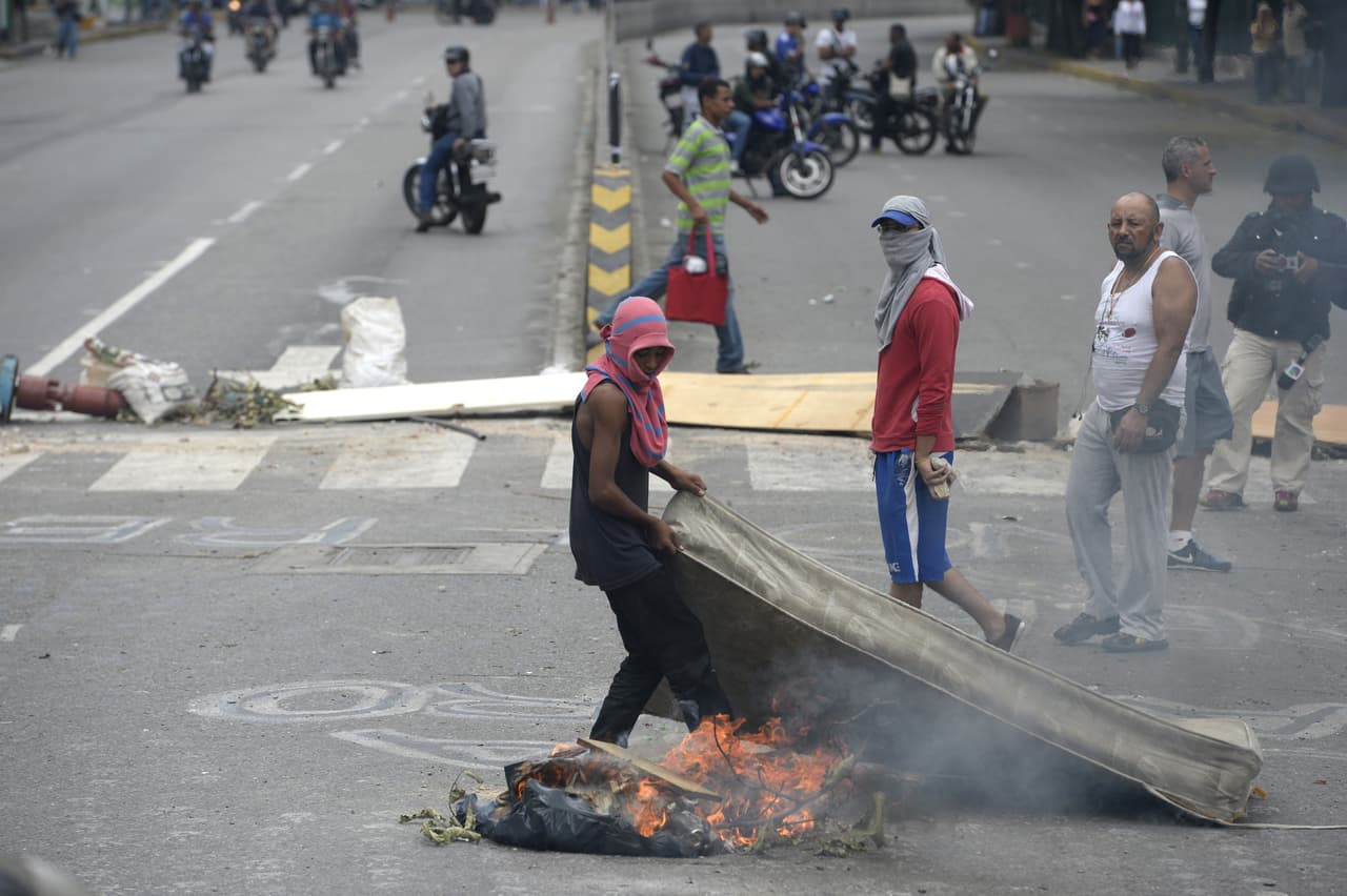 Un punto bloqueado por opositores en Caracas. En las protestas contra Maduro, algunos de los manifestantes han decidido tapar sus rostros, en algunos casos para evitar ser reconocidos por las fuerzas policiales y militares.