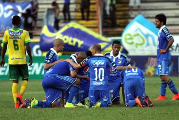 Los jugadores de Millonarios oran en el campo después de perder un partido entre Huila y Millonarios como parte de la octava jornada del futbol colombiano.