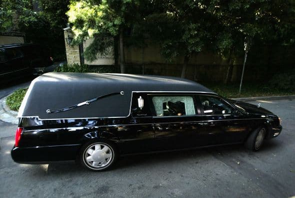 Un cadáver envuelto en una sábana se cae de un carro fúnebre en medio de una concurrida avenida 