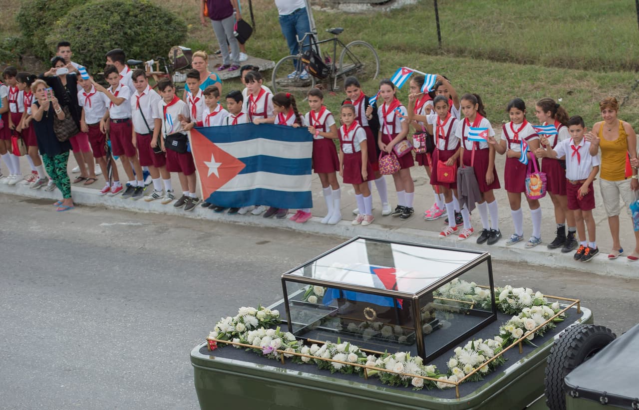 Un grupo de estudiantes ve pasar la caravana con las cenizas de Fidel Castro por Espíritu Santo, en el interior de Cuba.