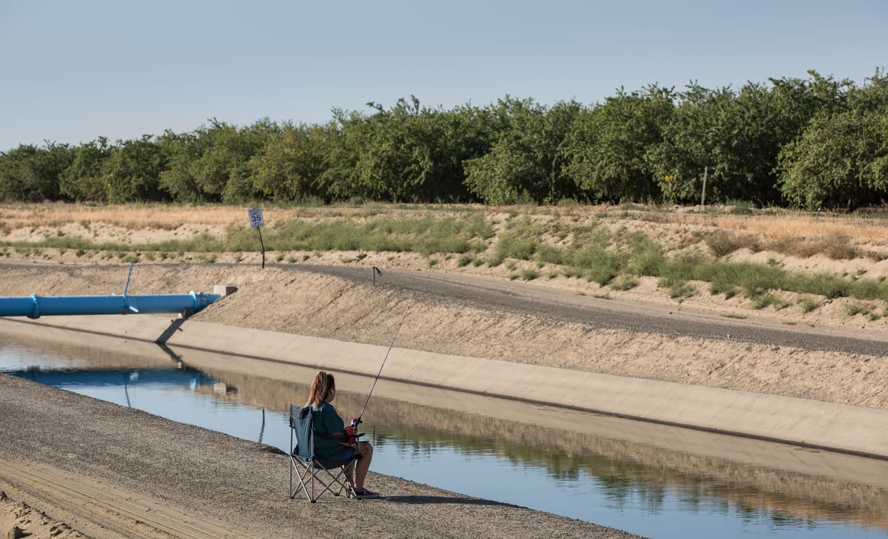 Un pescador en un canal casi seco en Harris Ranch, California, el 31 de mayo. Los recortes de agua están afectando a la industria agrícola de este estado, que emplea a decenas de miles de personas en muchos pueblos pequeños.