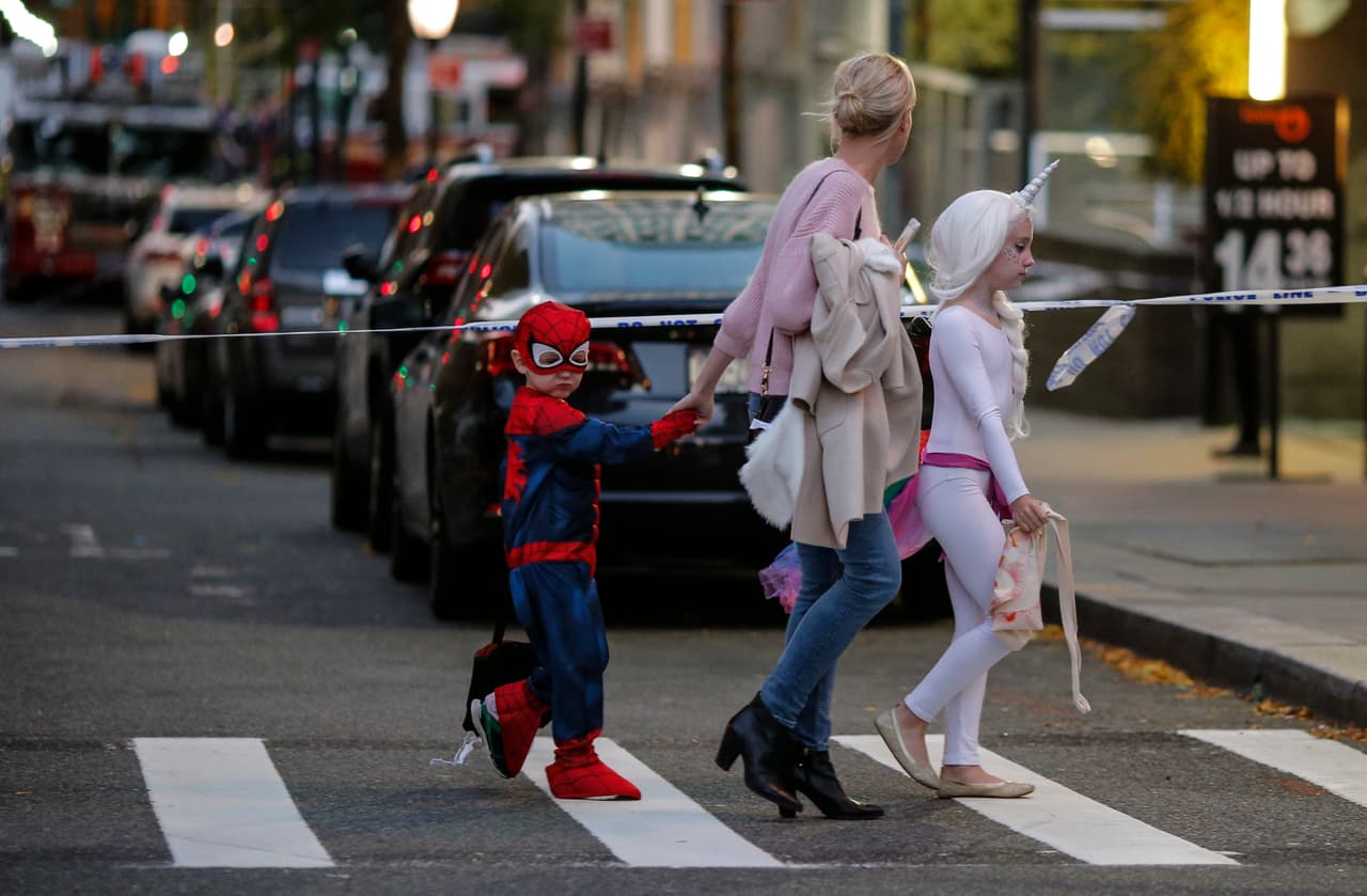 Unos niños disfrazados para la celebración de Halloween caminan cerca del lugar donde ocurrió el incidente en el sur de Manhattan.