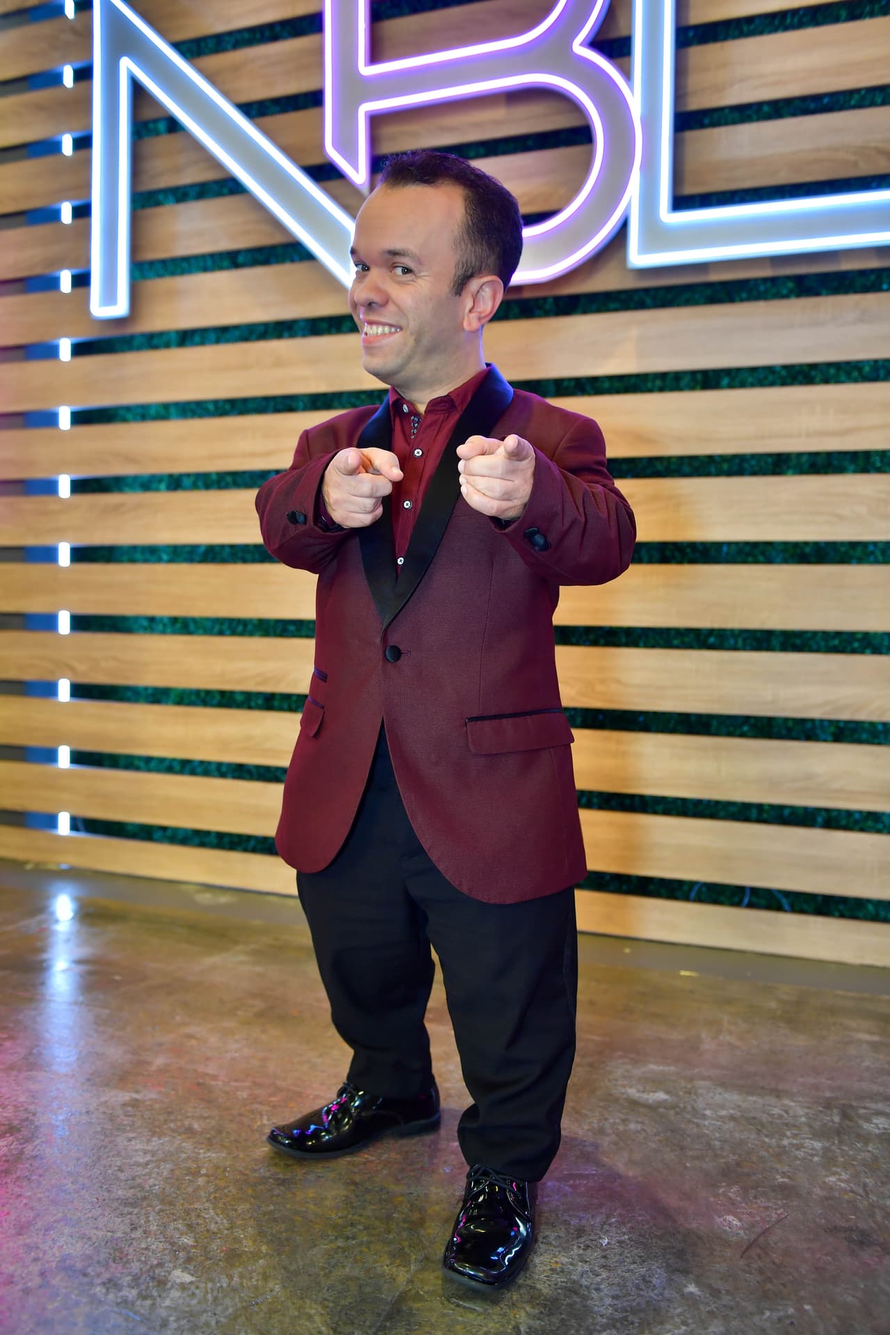 Carlitos 'El Productor' fue uno de los invitados que apoyaron a las participantes en esta noche y lo vimos con un traje guinda con negro.